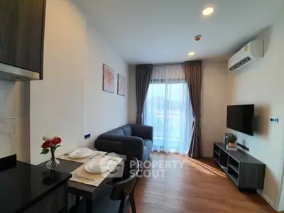 Modern living room with cozy seating and dining area, featuring natural light and stylish decor.