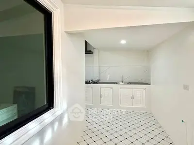 Modern kitchen with sleek white cabinetry and checkered tile flooring