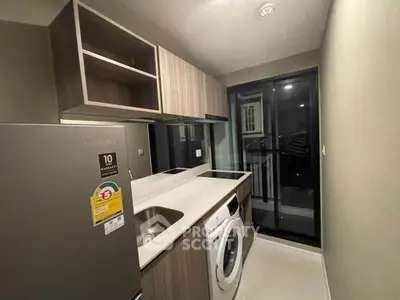 Modern kitchen with sleek appliances and balcony access in a stylish apartment.