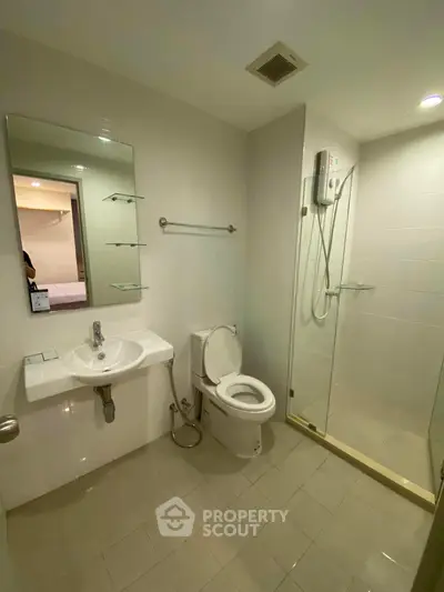 Modern bathroom with glass shower and sleek fixtures in a contemporary apartment.
