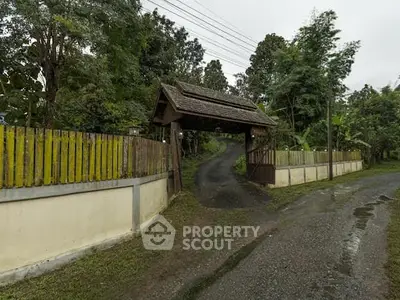 Charming rustic entrance with wooden gate and lush greenery