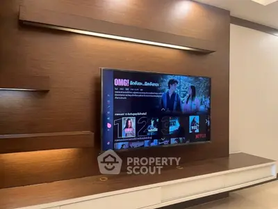 Modern living room with sleek wooden paneling and mounted flat-screen TV.
