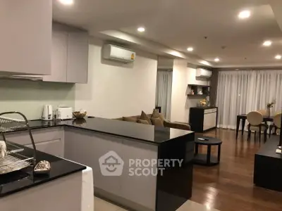 Spacious modern living room with open kitchen and elegant dining area, featuring sleek design and cozy ambiance.