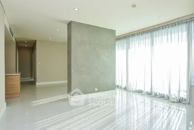 Spacious sunlit living room with floor-to-ceiling windows and modern design.