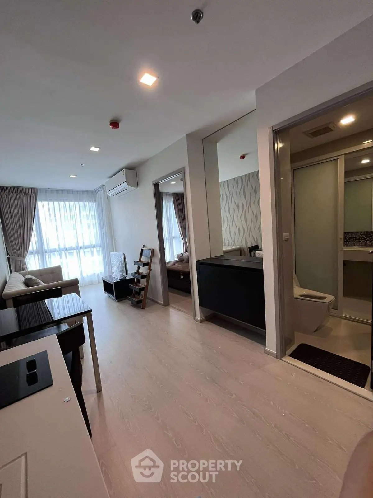 Modern apartment interior with open living room and bathroom, featuring stylish decor and natural light.