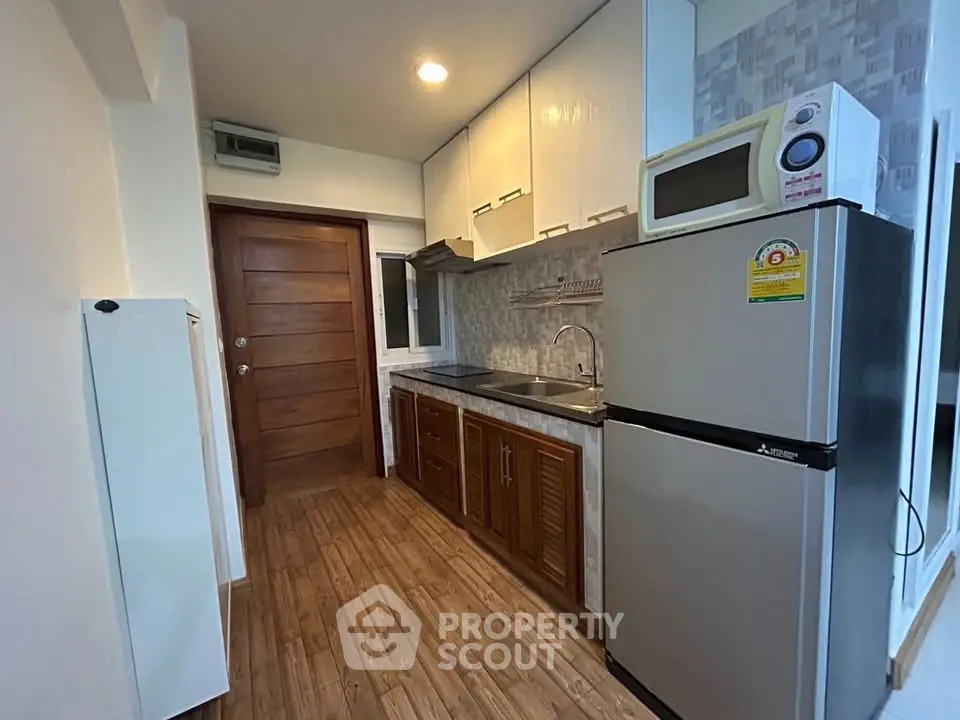 Modern kitchen with wooden cabinets and stainless steel appliances in cozy apartment