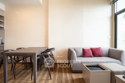 Modern living room with wooden dining table and cozy sofa, perfect for relaxation.