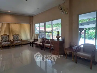 Spacious living room with elegant furniture and large windows overlooking garden area.