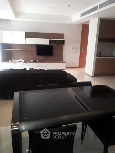 Modern living room with sleek furniture and open kitchen layout in a stylish apartment.