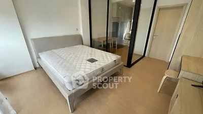 Modern bedroom with sleek design and ample natural light, featuring a comfortable bed and mirrored wardrobe.