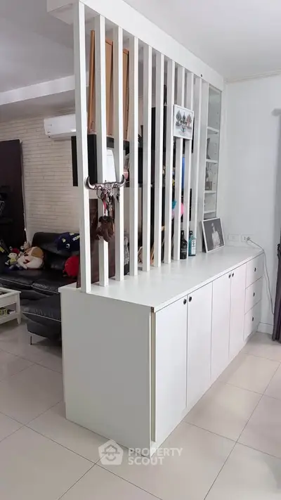 Modern living room with stylish partition and sleek white cabinetry