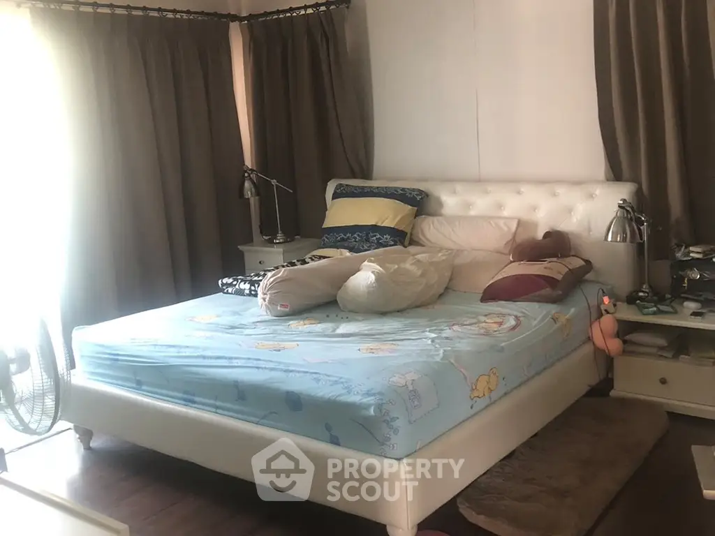 Cozy bedroom with plush bed and soft lighting, perfect for relaxation.