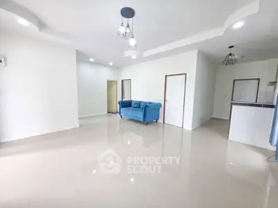Spacious living room with modern lighting and blue sofa in open layout
