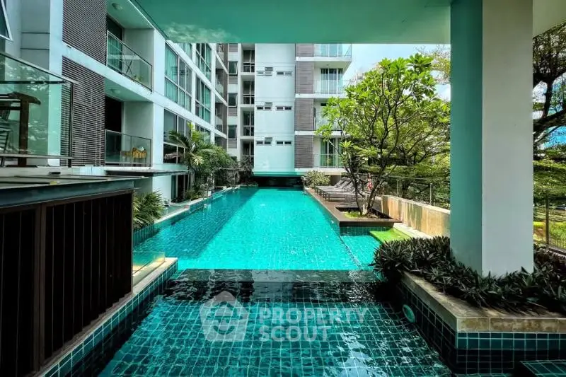 Luxurious condominium with stunning pool and lush greenery, perfect for relaxation and leisure.