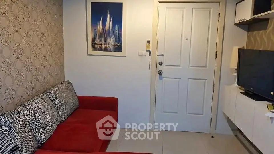 Cozy living room with red sofa and modern decor, perfect for relaxation.