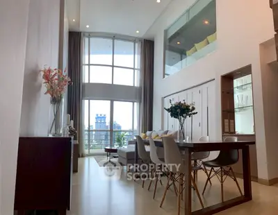 Luxurious high-ceiling living room with modern dining area and large windows.