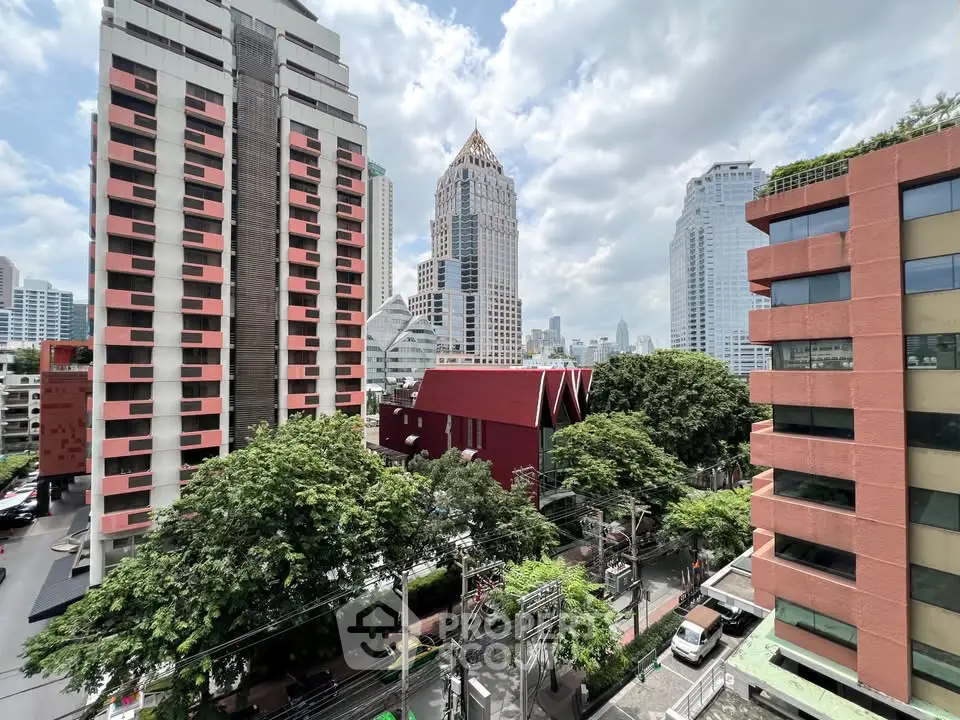 Stunning cityscape view from a high-rise apartment, showcasing modern architecture and lush greenery.