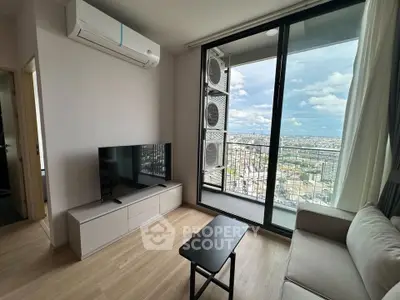 Modern living room with balcony and city view, featuring sleek furniture and air conditioning.