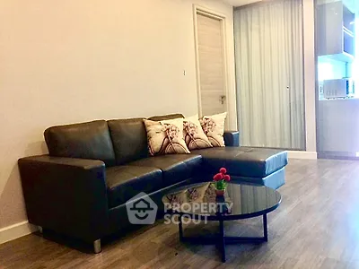 Modern living room with sleek black sofa and stylish decor in a contemporary apartment.