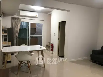 Modern open-plan living space with dining area and balcony access