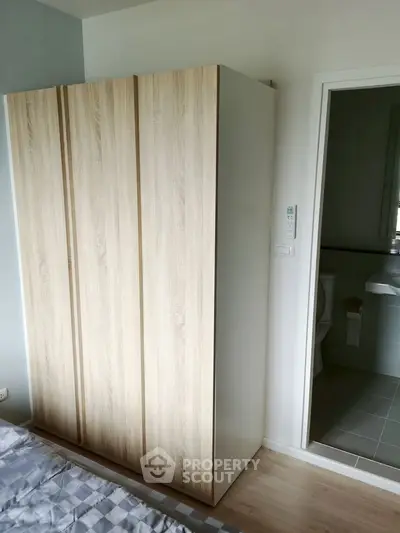 Modern bedroom with wooden wardrobe and adjacent bathroom