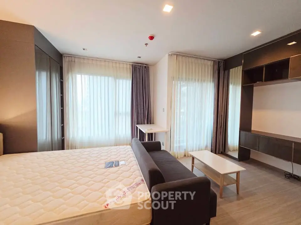 Spacious modern bedroom with large windows and stylish furnishings