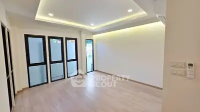 Spacious modern living room with large windows and elegant lighting