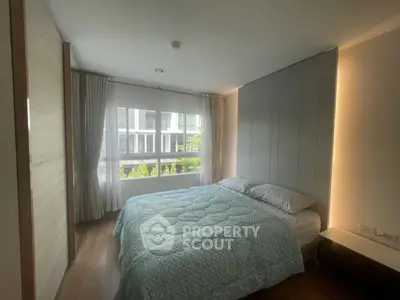 Modern bedroom with large window and cozy bedding in stylish apartment