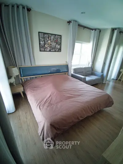 Spacious bedroom with modern decor and large windows for natural light