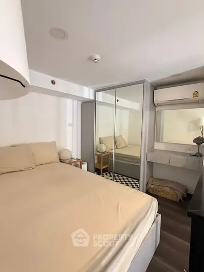 Cozy bedroom with mirrored wardrobe and modern decor in a stylish apartment.
