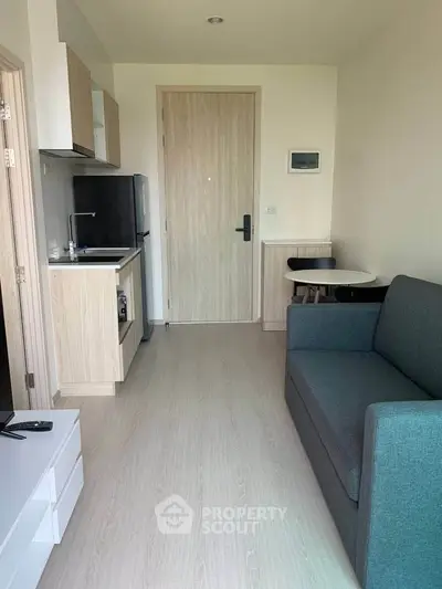 Modern compact studio apartment with kitchenette and cozy living area.