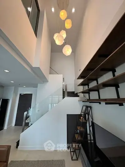 Modern living room with high ceiling and stylish pendant lights