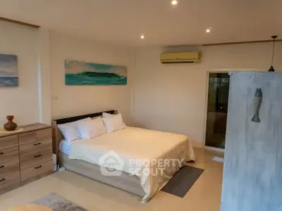 Spacious bedroom with modern decor and air conditioning in a stylish apartment.