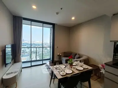 Modern living room with city view, stylish furniture, and dining area in a high-rise apartment.