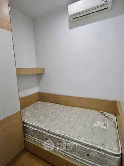 Compact bedroom with built-in storage and air conditioning