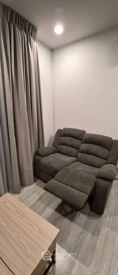 Cozy living room with plush recliner and elegant curtains