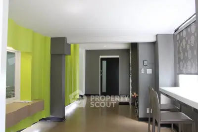 Modern living room with vibrant green accent wall and sleek furniture