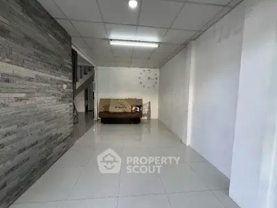 Spacious living room with modern tile flooring and stylish stone accent wall.