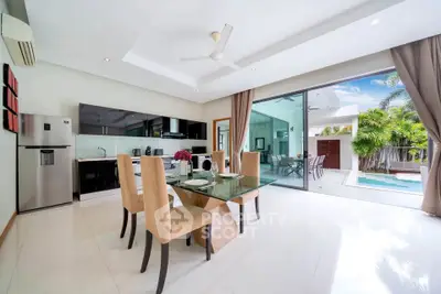 Luxurious open-plan kitchen and dining area with pool view in modern villa