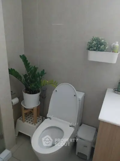 Modern bathroom with sleek toilet and stylish plant decor