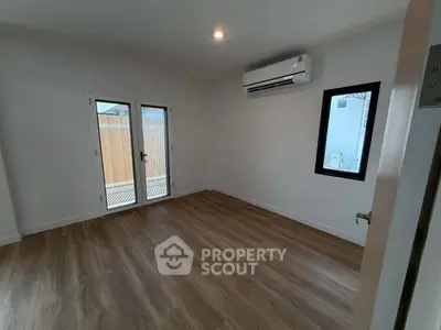 Spacious room with wooden flooring and air conditioning, perfect for modern living.