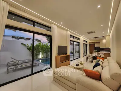 Luxurious open-plan living room with pool view and modern decor
