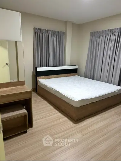 Modern bedroom with sleek wooden furniture and neutral curtains