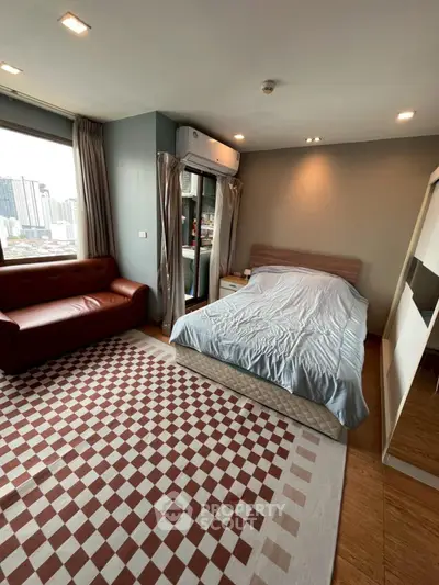 Spacious bedroom with city view, modern furnishings, and ample natural light.