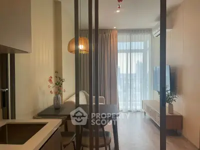 Modern living room with stylish decor and large window offering natural light.