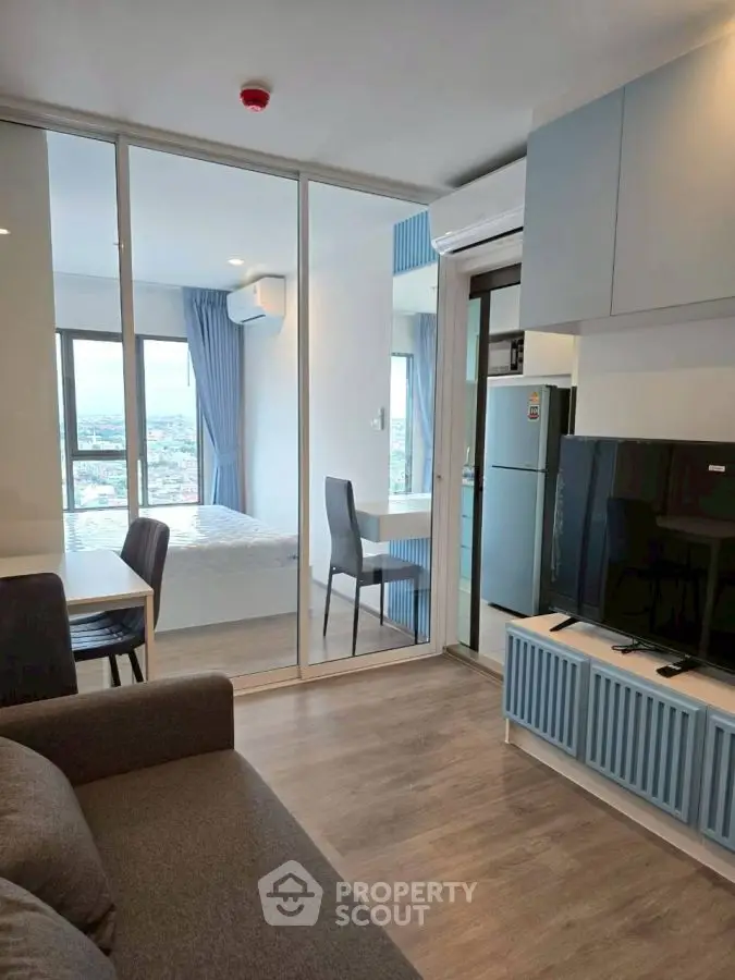 Modern apartment interior with open layout, featuring a cozy living area and a bright bedroom with city view.