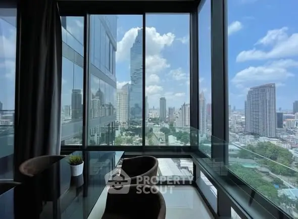 Stunning city view from modern high-rise apartment with floor-to-ceiling windows.