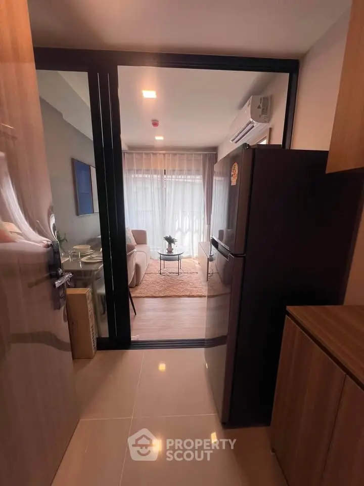 Modern apartment interior with open layout, featuring a cozy living room and sleek kitchen area.