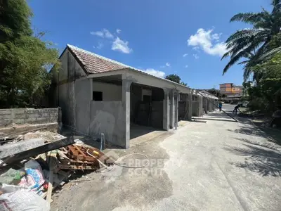 Under-construction building with open garages and clear blue sky