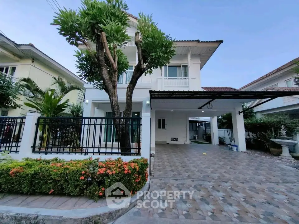 Charming two-story house with lush garden and spacious driveway in a serene neighborhood.